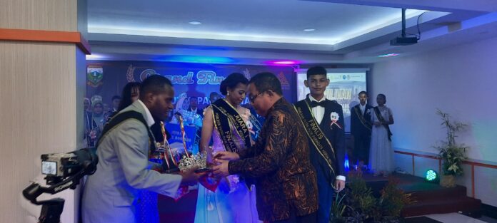 Wakil Bupati Keerom Drs. Wahfir Kosasih saat menyerahkan hadia kepada pemenang juara pertama para pemilihan Putra- Putri Pariwisata Kab Keerom Tahun 2023 di Grande Hotel Arso II.